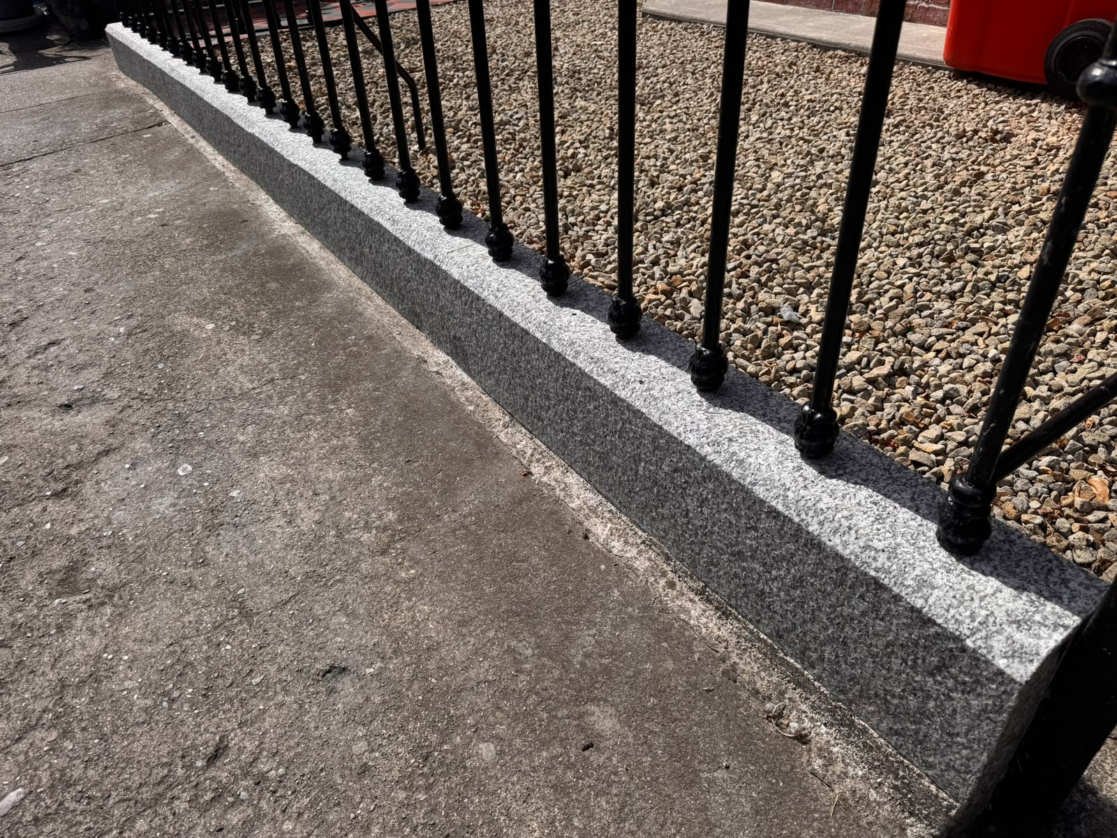 The same granite kerb and front boundary after cleaning — evenly cleaned grey stone