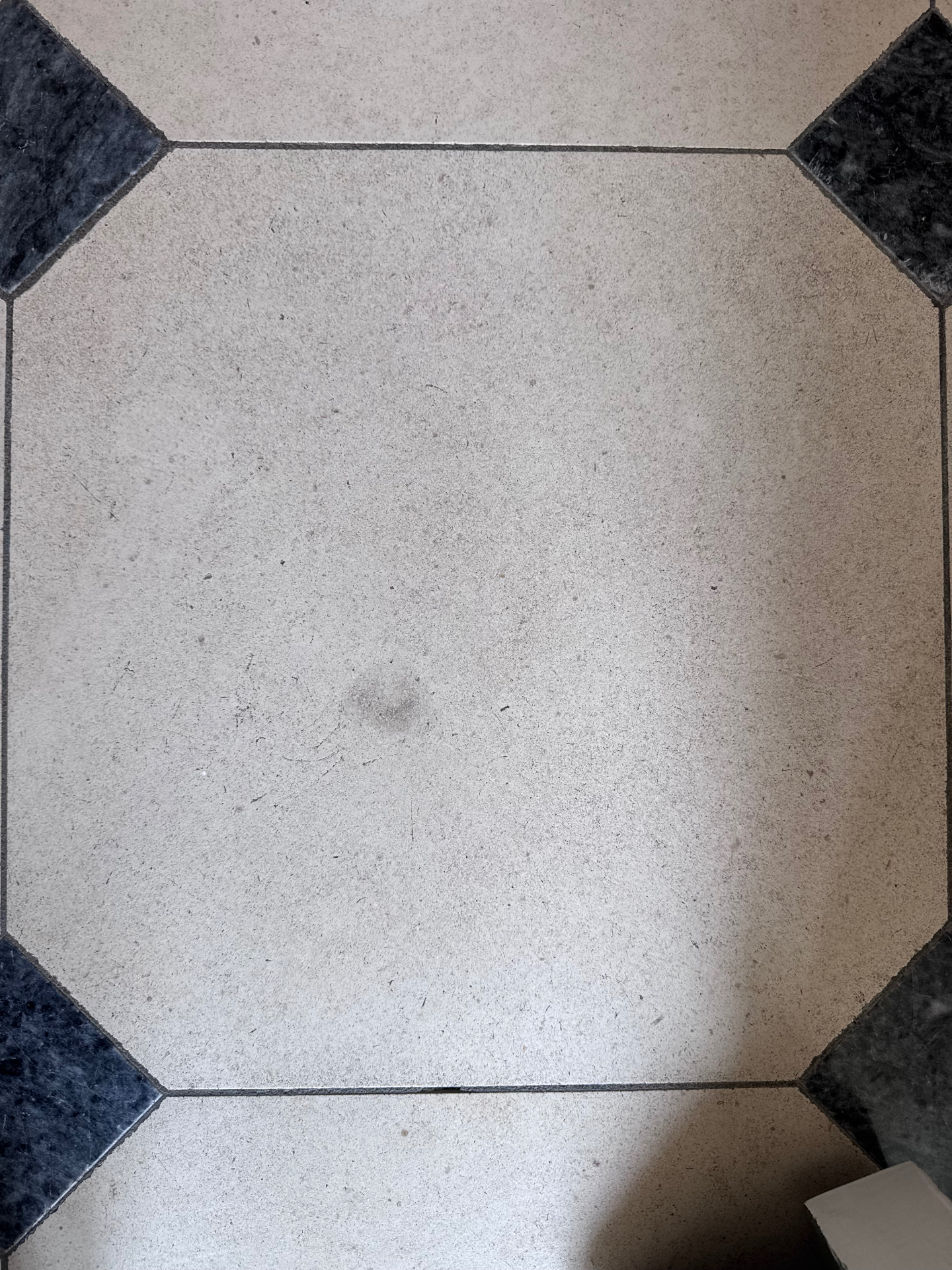 Limestone tile before restoration — dull, scratched and stained